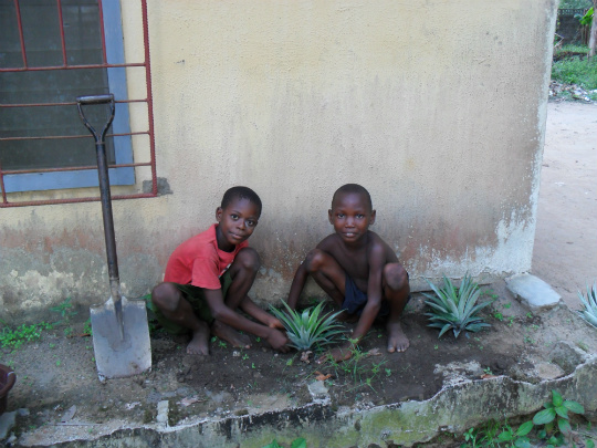 My neighbors Victor (left) and Moses helping me plant my first-ever garden.