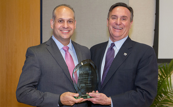 Acting College of Business Dean Jose Aldrich presents Wertheim Lecture recognition to John Zamora.