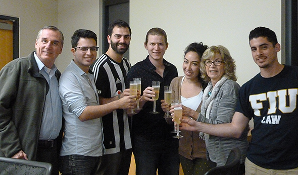 Chapman Cup Faculty Director Mark Del Pezzo (left) and Competition Coordinator Ellie Browner (second from right) join the students for a victory toast. 